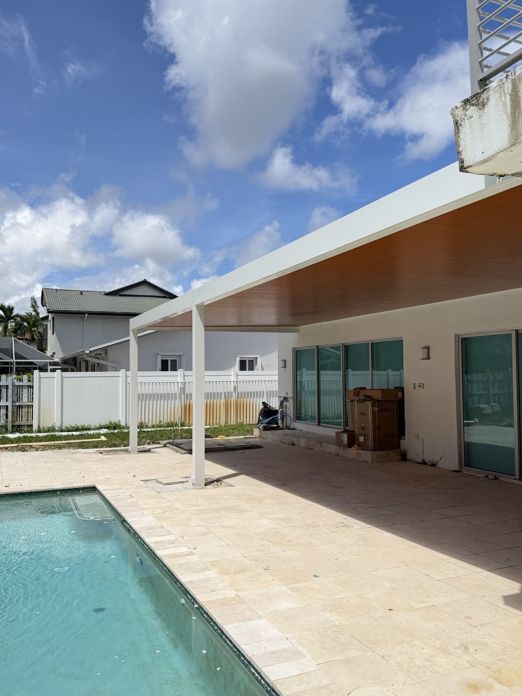 Pérgola de aluminio con techo de madera a la orilla de la piscina
