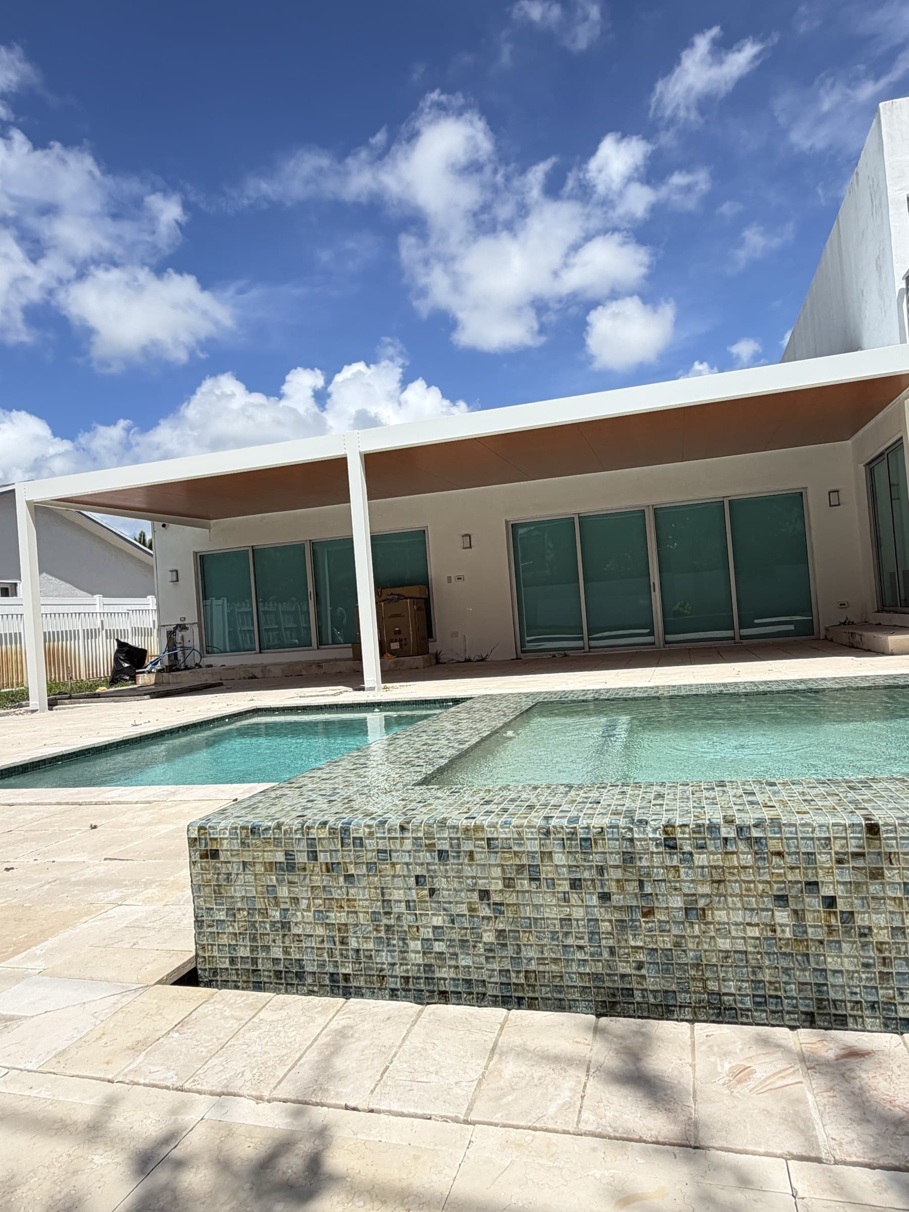 Pérgola de aluminio blanco junto a la piscina y el spa, en Miami